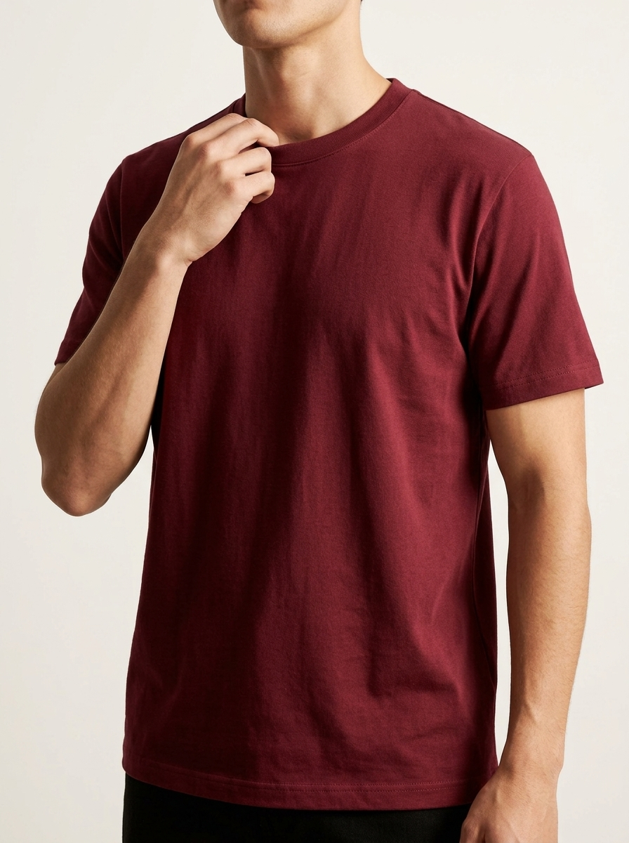 Person wearing a maroon t-shirt against a plain background