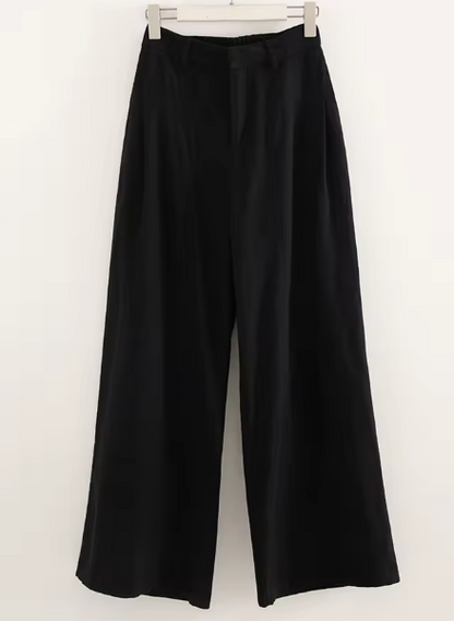 Black wide-leg pants on a hanger against a white background